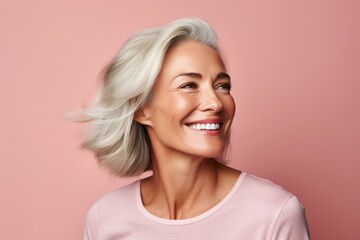 Portrait of smiling senior woman with white hair looking away over pink background