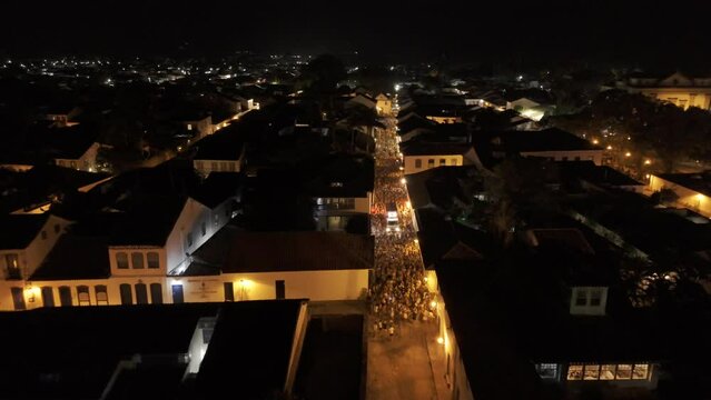 Aerial shot drone flies the length of historic center at night during a Carnaval bloco in Paraty
