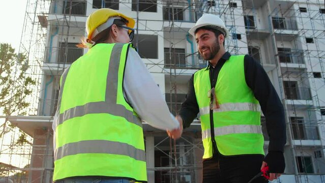 Happy team of architect or engineer with success and glad while handshake together at construction site, team contractor or partner glad with achievement about successful of project, industry concept.