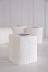 Soft toilet paper rolls on white wooden table
