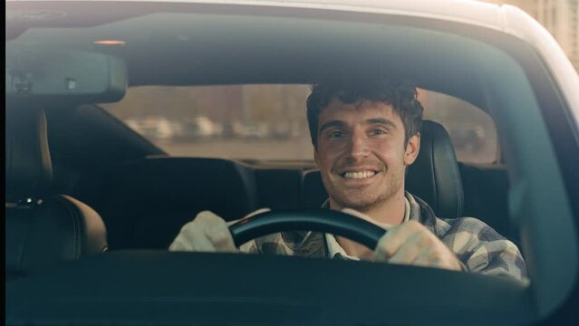 Happy Caucasian man car driver steering wheel enjoy travel trip drive modern electric automobile in city luxurious auto driving handsome guy smile inside suv crossover rent buy vehicle road adventure