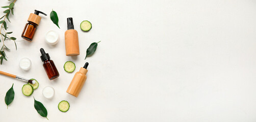 Natural cosmetic products, cucumber and plant leaves on light background with space for text
