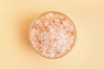 Glass bowl with Himalayan pink salt on orange background