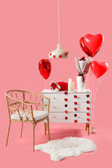 Chest of drawers and armchair with decorations for Valentine's Day celebration on pink background