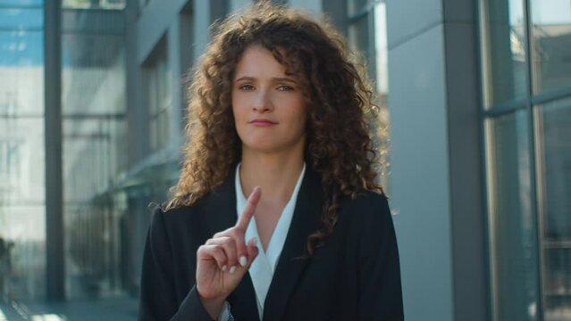 Confident woman Caucasian business girl in city serious looking at camera shaking finger prohibit warning gesture stop no never warn refuse deny female dissatisfied businesswoman waving hand forbid