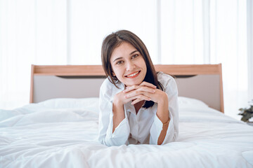 Happy fresh young woman stretching in bed waking up alone happy concept, smiling woman lady awake after healthy sleep sitting in cozy comfortable bedroom interior enjoy good morning.