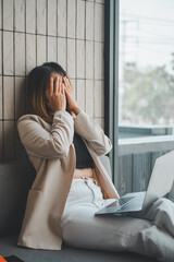 Visibly upset businesswoman covers her face, seeking a moment of respite from the stresses of work...