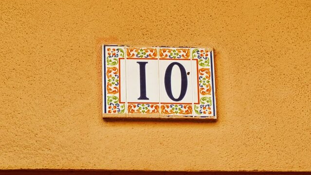 Number 10 (ten) affixed to the exterior of a building, with an elegant, vintage and traditional appearance