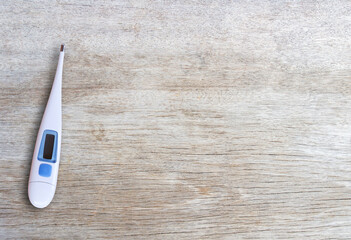 Medical healthy equipment. Digital thermometer on wood table background.