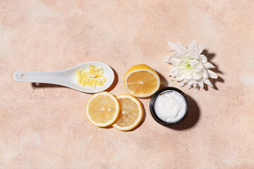 Composition with jar of cosmetic product, lemon and flower on color background