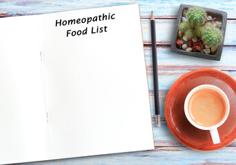 Homeopathic food list text on blank notebook,pencil and coffee on wood table background