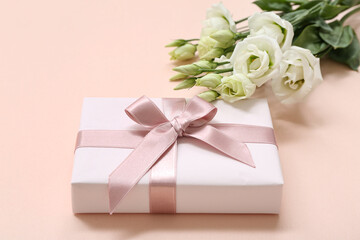 Gift box and beautiful white eustoma flowers on pink background. International Women's Day
