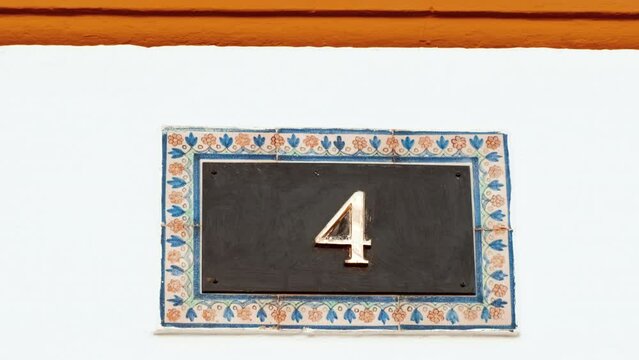 Number 4 (four) affixed to the exterior of a building, with an elegant, vintage and traditional appearance