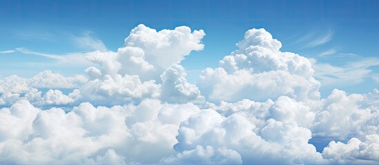 A plane can be seen soaring through a vivid blue sky filled with fluffy white clouds. The aircraft stands out against the backdrop of the dynamic cloud formations as it navigates through the