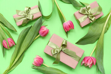 Gift boxes and beautiful tulips on green background. International Women's Day
