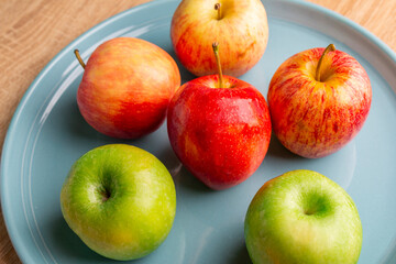 delicious apples on a wooden table, bitten apple, red apple and green apple