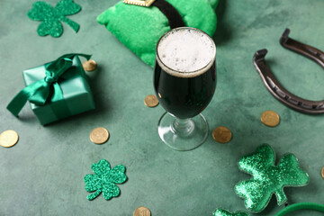 Glass of dark beer with leprechaun hat, gift box and horseshoe for St. Patrick's Day celebration on...