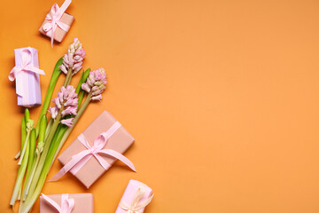 Gift boxes and hyacinth flowers on orange background. Top view