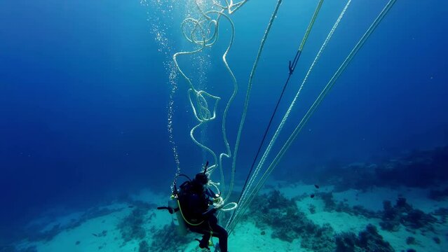 Scuba diver using ropes to descend in sea water safely water pressure co2