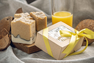 Bright fragrant pieces of fruit natural soap and a craft gift box with a yellow ribbon