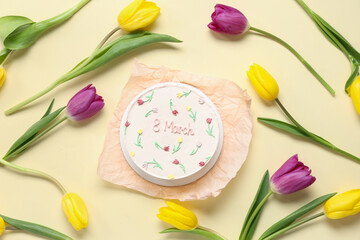 Sweet bento cake and beautiful tulips on yellow background. International Women's Day