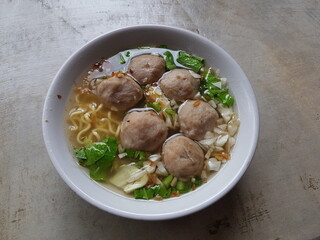 Bowl with tasty meatball soup and ingredients potatoes, spices and vegetables on wooden table. Top view. selective focus.