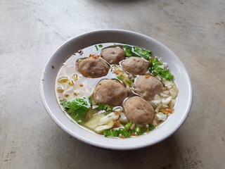 Bowl with tasty meatball soup and ingredients potatoes, spices and vegetables on wooden table. Top view. selective focus.