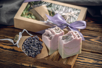 Beautiful gift box with natural soap and a bouquet of lavender on the table, and pieces of organic...