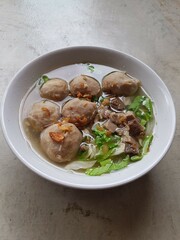 Bowl with tasty meatball soup and ingredients potatoes, spices and vegetables on wooden table. Top view. selective focus.