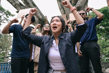 Woman activist leading the demonstrations, raising hands while others raising blank cardboard