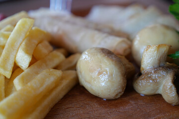 Close up shot of a dish featuring French fries and mushrooms on a plate
