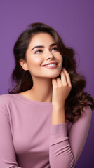 Fototapeta premium Beautiful smiling woman thinking about her inspiration with hand touching her chin to search product options isolated on purple color background 
