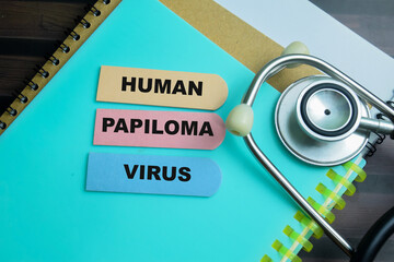 Concept of Human Papiloma Virus write on sticky notes with stethoscope isolated on Wooden Table.