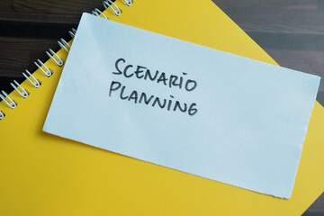 Concept of Scenario Planning write on sticky notes isolated on Wooden Table.