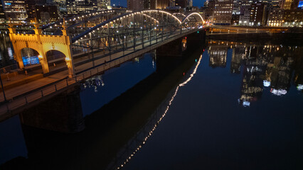 City bridge reflects in river at night