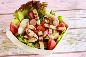 Mixed Salad with tomato, cucumber, mushroom, lettuce leave and cheese served in dish isolated on table closeup top view of healthy organic food