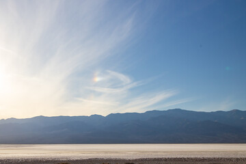 Sun dog and clouds over the salt flats at Badwater Basin in Death Valley National Park, California