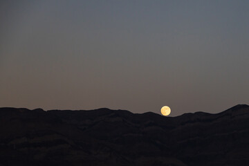 Fototapeta premium Full moon rising, mountain background