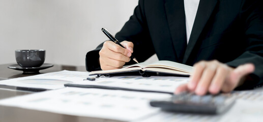 The businessman hand sits at their desks and calculates financial graphs showing the results of their investments planning the process of successful business growth