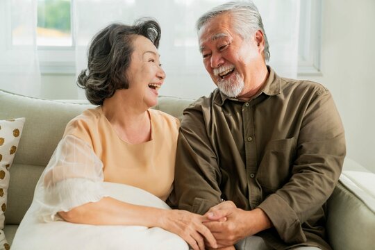 Old Senior Asian Retired Age Marry Couple Wellness Lifesstyle Together Homeold People Laugh Smile Together With Love Bonding Sofa Living Room Home Interior Background