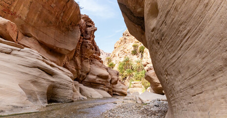Beautiful majesty of mountains in path of the shallow stream in the gorge Wadi Al Ghuwayr or An...