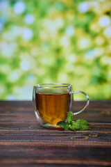glass cup of natural organic herbal tea on a wooden table