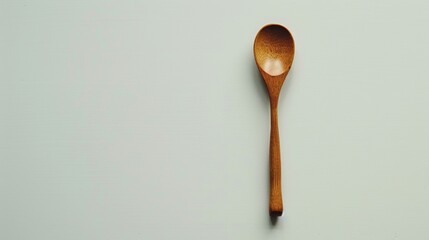 Minimalist beechwood spoon on a pristine white surface, embodying simplicity and functionality in culinary tools.