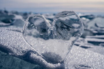 An icy heart in the sunset. An icicle in the shape of a heart on the ice of the lake. Frozen. Love...