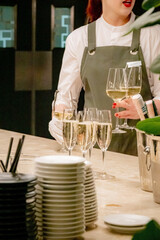 waiter pouring champagne into a wineglass at a wedding reception