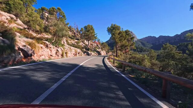 Sunny POV drive on Palma de Mallorca's mountain road. Scenic car journey in vibrant surroundings