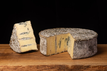 blue cheese on a wooden board on a black background