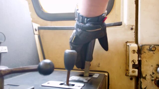 Close-up of a train driver's hand operating controls in the cabin during a journey in Alausi, Ecuador