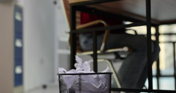 Female secretary throws crumpled paper into trash