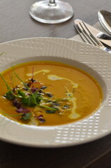 yellow cream soup , with pumpkin seeds, background of delicious healthy food for vegetarians , served food in restaurant